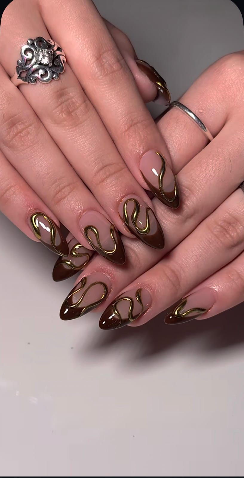 Hand wearing brown Almond -shaped press-on nails
