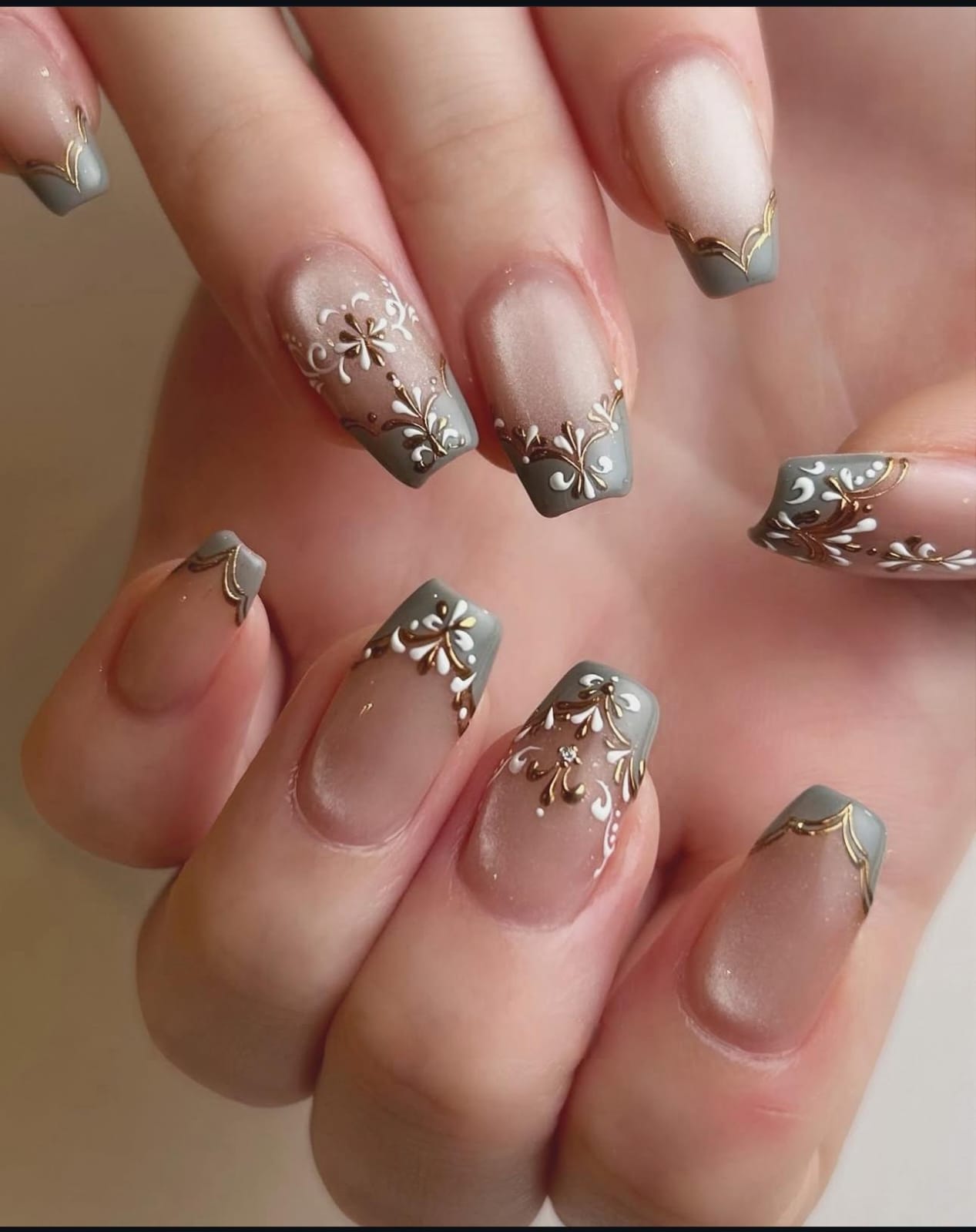 Hand wearing pink coffin-shaped press-on nails