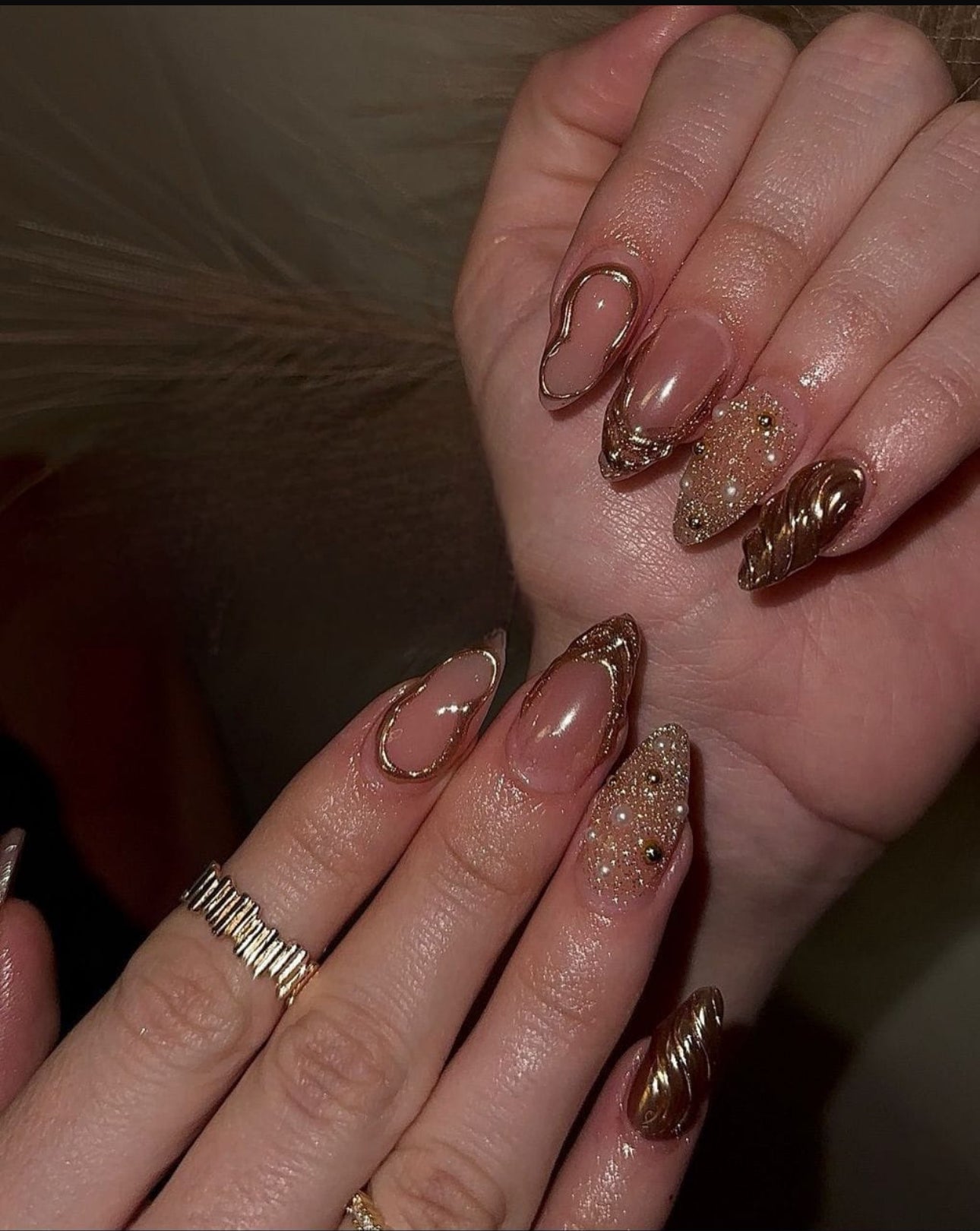 Hand wearing golden luxe -shaped press-on nails