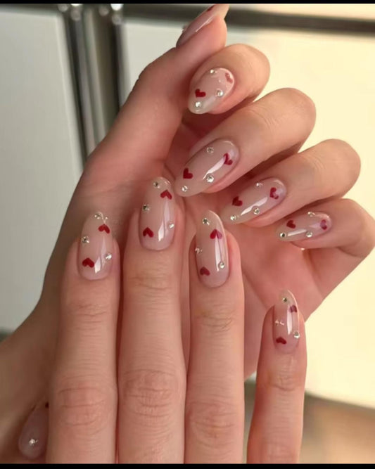 Hand wearing pink heart Almond -shaped press-on nails